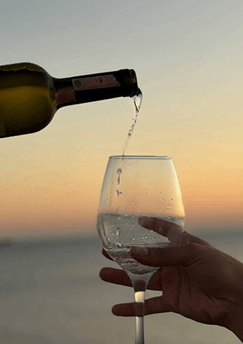 A glass of wine filled at sunset