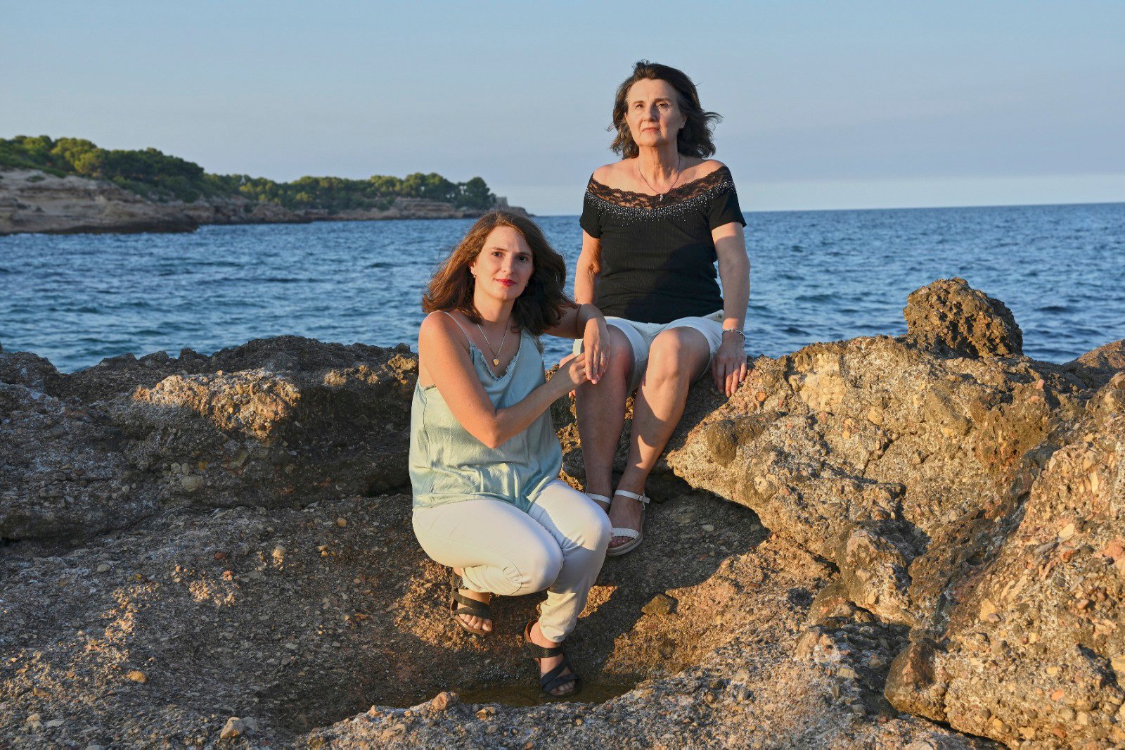 sitting on rocks at the foot of the sea