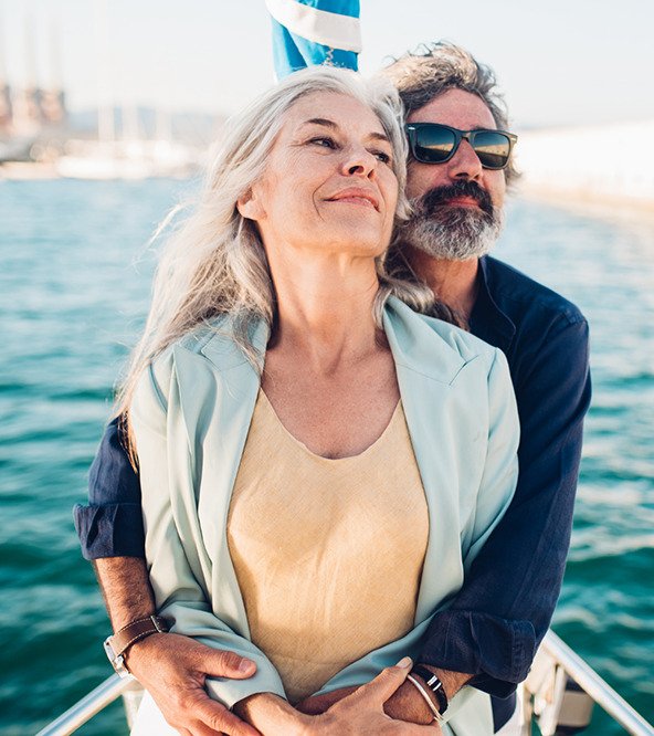 A mature couple on board a boat, with the sea in the background